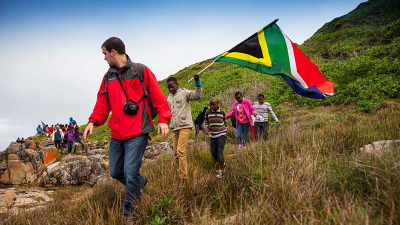 Walking on hillside with South African flag